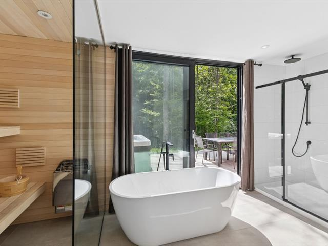 Luxury bathroom with freestanding soaking tub and forest views